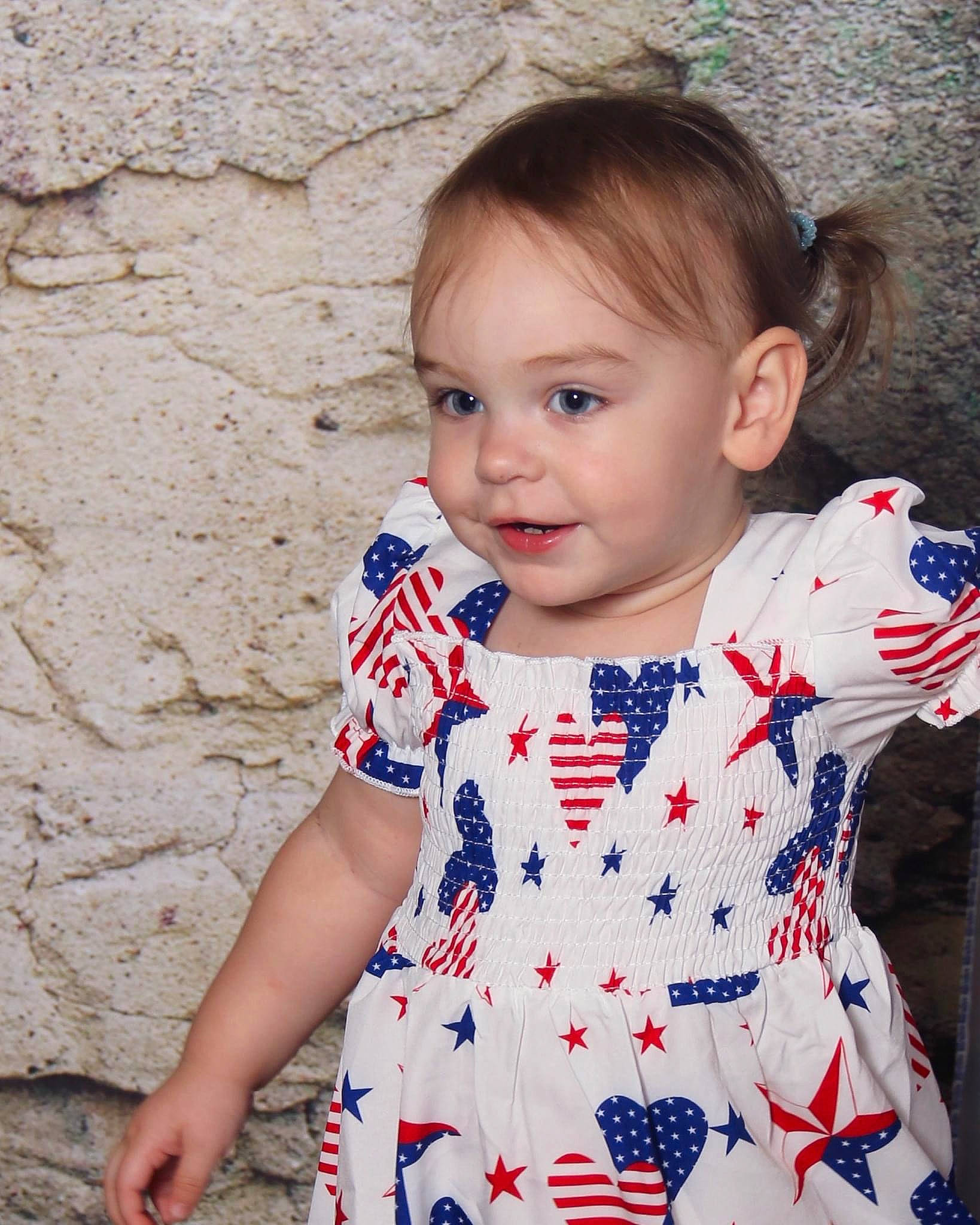 Octavia is registered to the contest to win money with this photo: baby, baby_toddler_clothing, blue, cheek, day_dress, dress, happy, head, iris, lip, neck, one_piece_garment, outerwear, pattern, person, skin, sleeve, smile, standing, t_shirt