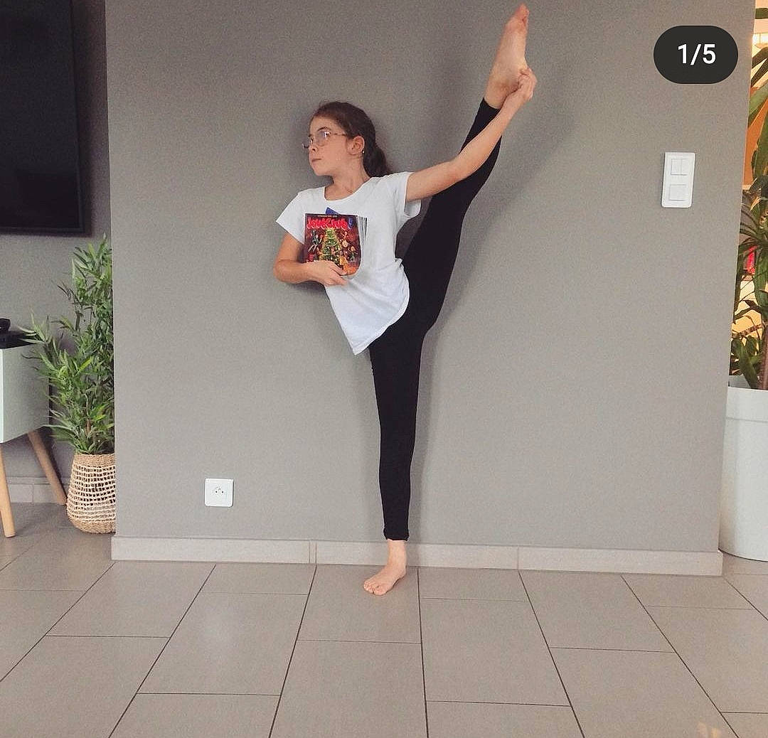 Lisa participe au concours pour gagner de l'argent avec cette photo : active_pants, balance, barefoot, elbow, floor, flooring, houseplant, joint, knee, leg, neck, person, plant, shoulder, sleeve, sportswear, sweatpant, t_shirt, thigh, trunk