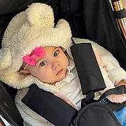 Charlotte participe au concours pour gagner de l'argent avec cette photo : baby, blue_eyes, bundle, child, clothing, cute, expression, face, fur, hood, infant, jacket, outdoor_gear, person, pink_bow, portrait, seatbelt, stroller, warm, young