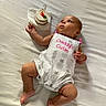 Mary Rose joined the competition — help win amazing prizes! baby, infant, birthday, cake, candle, bed, bedroom, lying_down, white_bedding, portrait, curious, looking_up, onesie, dress, pink, silver, hand, feet, celebration, indoor