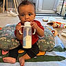 Bryson joined the competition — help win amazing prizes! baby, blanket, bottle, carpet, child, clothing, curtain, cushion, face, floor, foot, furniture, hand, indoor, milk, person, room, sitting, toy, window