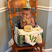 Bryson joined the competition — help win amazing prizes! baby, birthday, cake, celebration, child, cute, decor, eating, face, flooring, food, green_wall, hands, high_chair, home_interior, infant, messy, party_hat, tassels, wooden_chair