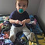 Julian joined the competition — help win amazing prizes! toddler, child, pacifier, bed, blanket, colorful, sitting, indoor, clothing, socks, person, young_child, curious, holding, toy, soft, cozy, looking_up, hair, face