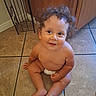 baby, child, curly_hair, smile, diaper, floor, tile, kitchen, cabinet, happy, cute, sitting, indoors, person, skin, infant, young_child, one_person, looking_up, joyful
