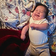 Frankie is registered to the contest to win money with this photo: baby, smiling, blanket, bed, clothing, happy, infant, person, sleepwear, cute, face, skin, head, lying_down, toddler, indoor, comfort, soft, warm, child