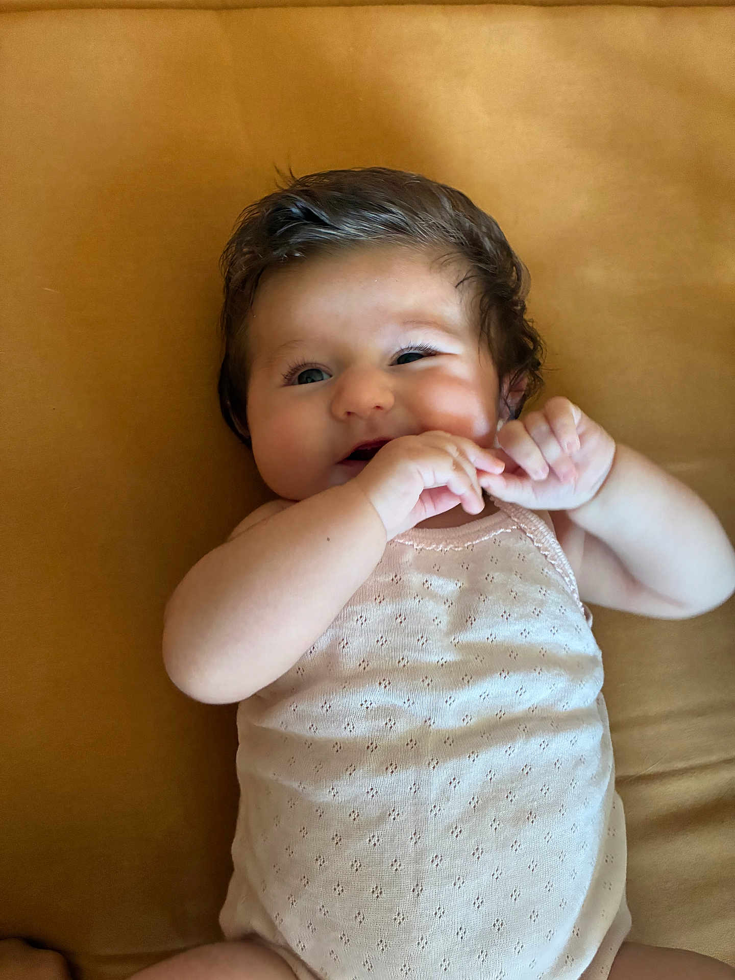 Charlie participe au concours pour gagner de l'argent avec cette photo : baby, infant, child, smiling, face, hand, skin, hair, clothing, sleeveless, lying_down, bed, fabric, cute, playful, portrait, closeup, expression, indoors, person