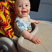 Otis is registered to the contest to win money with this photo: baby, blanket, child, colorful, cooking, cute, face, feeding, food, fun, hand, happy, high_chair, indoor, meal, mess, messy, shirt, smiling, spaghetti