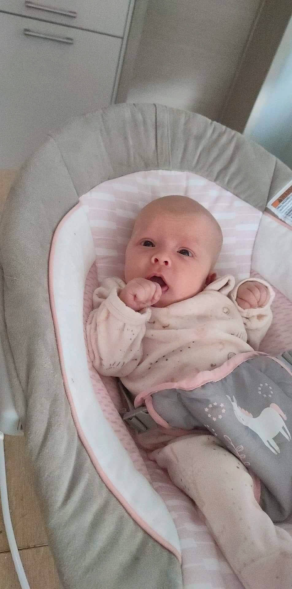 Yliana a rejoint le concours — aidez-le/la à gagner de superbes lots ! baby, baby_carriage, baby_products, baby_safety, baby_sleeping, baby_toddler_clothing, cheek, child, comfort, eye, infant_bed, linens, person, product, room, sitting, skin, thumb, toddler