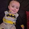 baby, child, infant, portrait, smiling, happy, sitting, couch, sofa, batman, superhero, costume, clothing, gray_outfit, black, yellow, red_cushion, indoor, home, face
