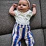 Victoire participe au concours pour gagner de l'argent avec cette photo : baby, infant, couch, gray_couch, headband, white_shirt, striped_pants, sock, raised_arms, face, cheeks, lying_down, indoor, fabric_texture, smiling, cute, child, person, comfortable, relaxed