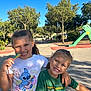 Lila participe au concours pour gagner de l'argent avec cette photo : child, children, smiling, outdoor, playground, trees, sunlight, daytime, candy, friendship, happy, green_tshirt, white_tshirt, blue_sky, play_equipment, cute, portrait, casual_clothing, summer, fun