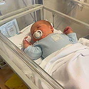 Hunter is registered to the contest to win money with this photo: newborn, baby, hospital, bassinet, pacifier, blanket, sleeping, medical_equipment, clothing, infant, crib, person, child, healthcare, bed, hospital_room, cute, resting, indoors, peaceful