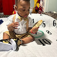 Amor joined the competition — help win amazing prizes! blanket, bow_tie, boy, child, clothing, cozy, curious, face, hair, hand, indoor, numbers, room, shorts, sitting, sneakers, suspenders, toddler, white_shirt, wooden_object