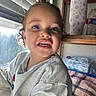 Asiah joined the competition — help win amazing prizes! blanket, casual_clothing, child, curly_hair, cute, expression, face, home, indoors, natural_light, person, plaid, portrait, shelf, smiling, sweatshirt, teeth, toddler, water_bottle, window