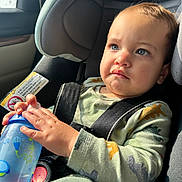 Asiah joined the competition — help win amazing prizes! toddler, child, car_seat, sippy_cup, blue_eyes, pajamas, dinosaur_pattern, seatbelt, car_interior, sunlight, serious_expression, clothing, hand, face, person, young_child, infant, baby, seat, window