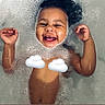 child, toddler, bath, foam, bubbles, water, smile, happy, arms, skin, hair, face, cloud_emoji, playful, joy, splash, bathtub, cute, young_child, fun