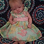 baby, background, blurred, child, colorful, cute, dress, fabric, floral, footwearless, indoors, infant, patterned_blanket, person, portrait, sitting, small_feet, small_hands, soft_colors, young