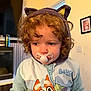Harriet joined the competition — help win amazing prizes! toddler, child, pacifier, curly_hair, hood, cat_ears, bluey, clothing, indoor, television, picture_frame, face, portrait, cozy, cute, expression, young_child, wearing, colorful, casual
