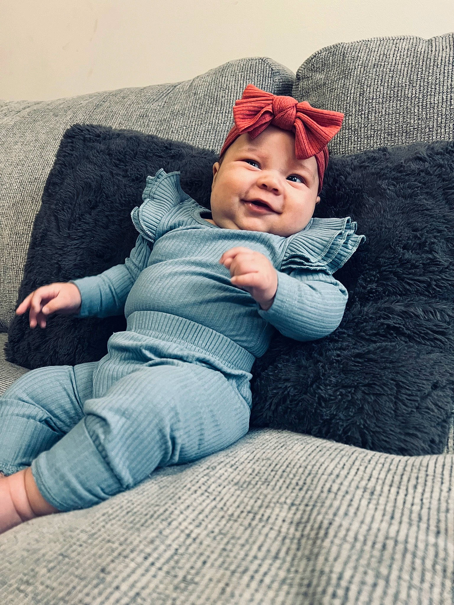 Haisleigh joined the competition — help win amazing prizes! baby, baby_toddler_clothing, cap, comfort, couch, grass, grey, happy, hat, headwear, human_leg, leg, linens, outerwear, pattern, person, sitting, sleeve, smile, t_shirt