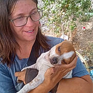 Majesty is registered to the contest to win money with this photo: affection, animal, brown_hair, casual, daylight, dog, face, glasses, greenery, hand, holding, nature, outdoor, person, pet, relaxation, resting, short_sleeve_shirt, sleepy, woman