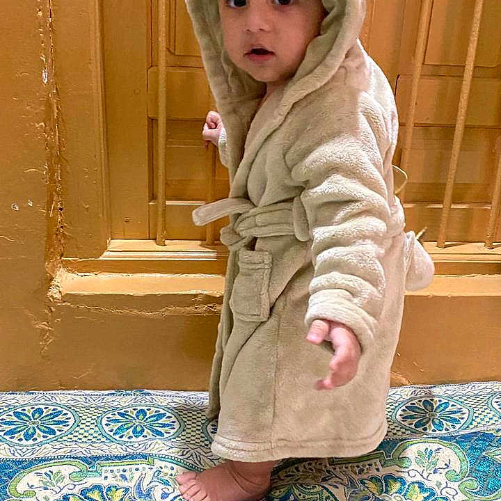 Haider joined the competition — help win amazing prizes! baby, babycrawling, blanket, bonnet, clothing, crawling, face, fashion, hat, head, hood, person, photography, portrait, robe, sitting, sleeve, standing