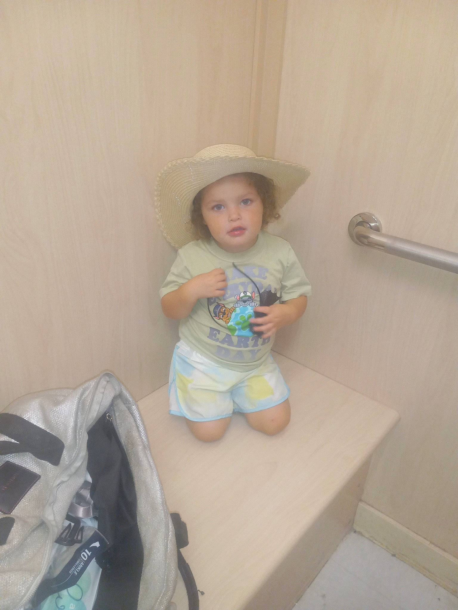 Nova is registered to the contest to win money with this photo: baby, baby_toddler_clothing, bag, child, comfort, diaper, face, fun, hat, head, headwear, human_leg, knee, person, room, shorts, sitting, sleeve, sun_hat, t_shirt