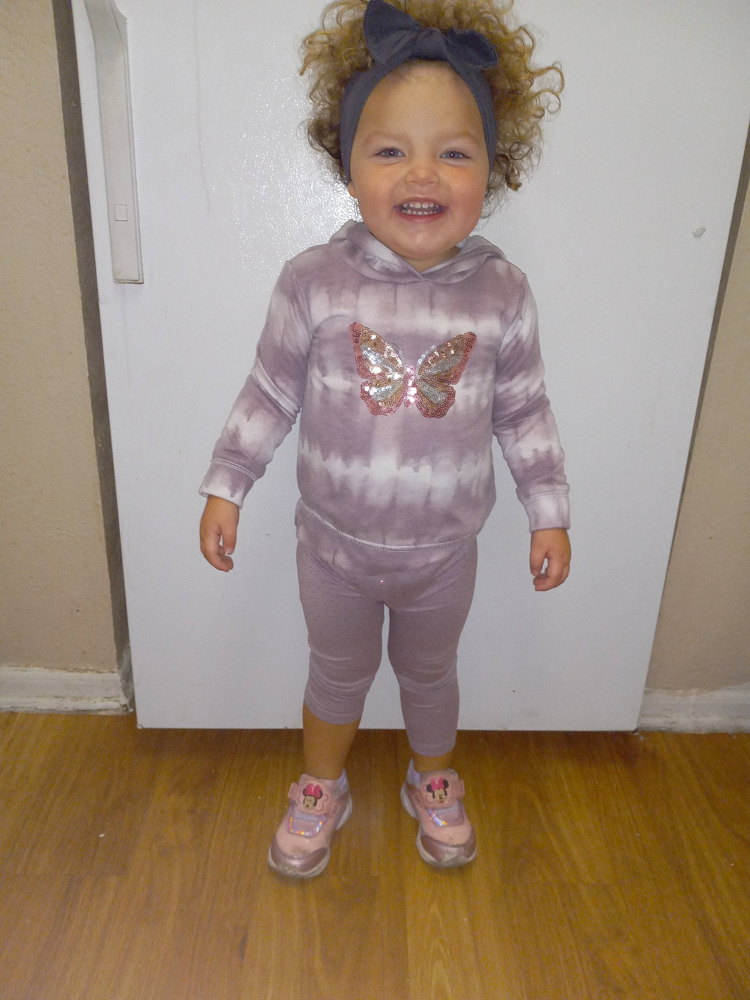 Nova is registered to the contest to win money with this photo: baby_toddler_clothing, blond, cheek, child, face, flooring, gesture, hair, happy, hardwood, head, joy, laminate_flooring, person, sleeve, smile, standing, toddler, varnish, wood