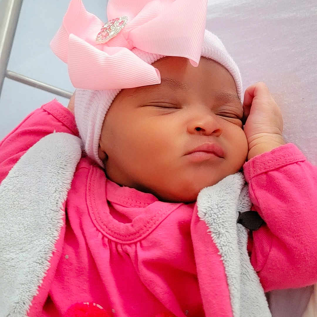 Aïda participe au concours pour gagner de l'argent avec cette photo : adorable, baby, blanket, bow, child, closeup, cozy, cute, face, hand, headwear, indoors, infant, peaceful, pink_clothing, portrait, rest, sleeping, soft_texture, toy