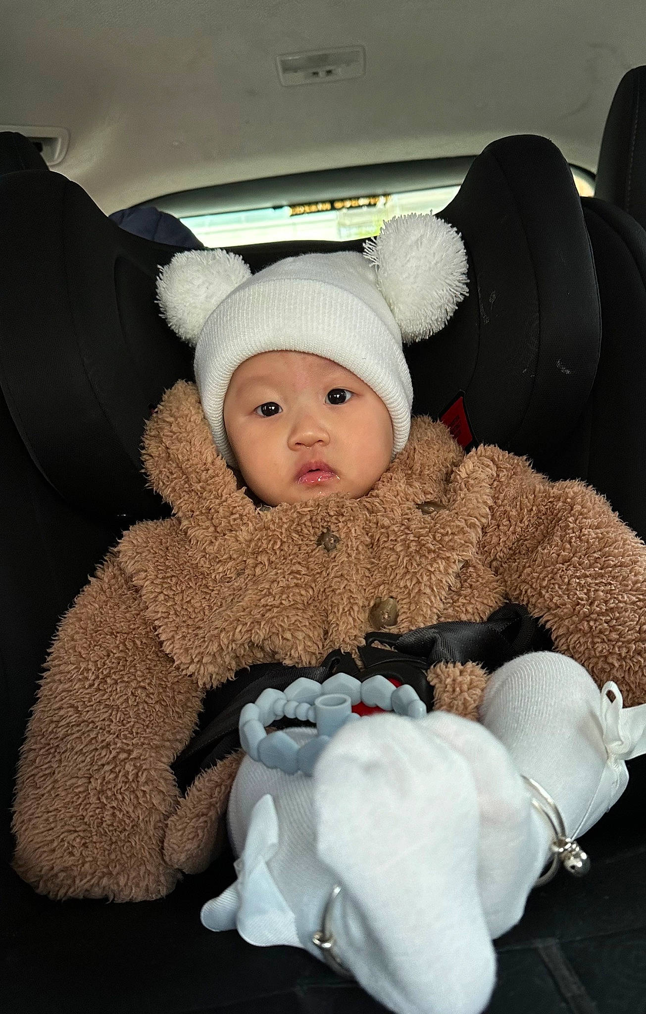 Genevieve is registered to the contest to win money with this photo: baby, baby_products, baby_sleeping, baby_toddler_clothing, beanie, cap, car_seat, cheek, child, comfort, fur, headgear, headwear, knit_cap, linens, luxury_vehicle, person, room, sitting, teddy_bear