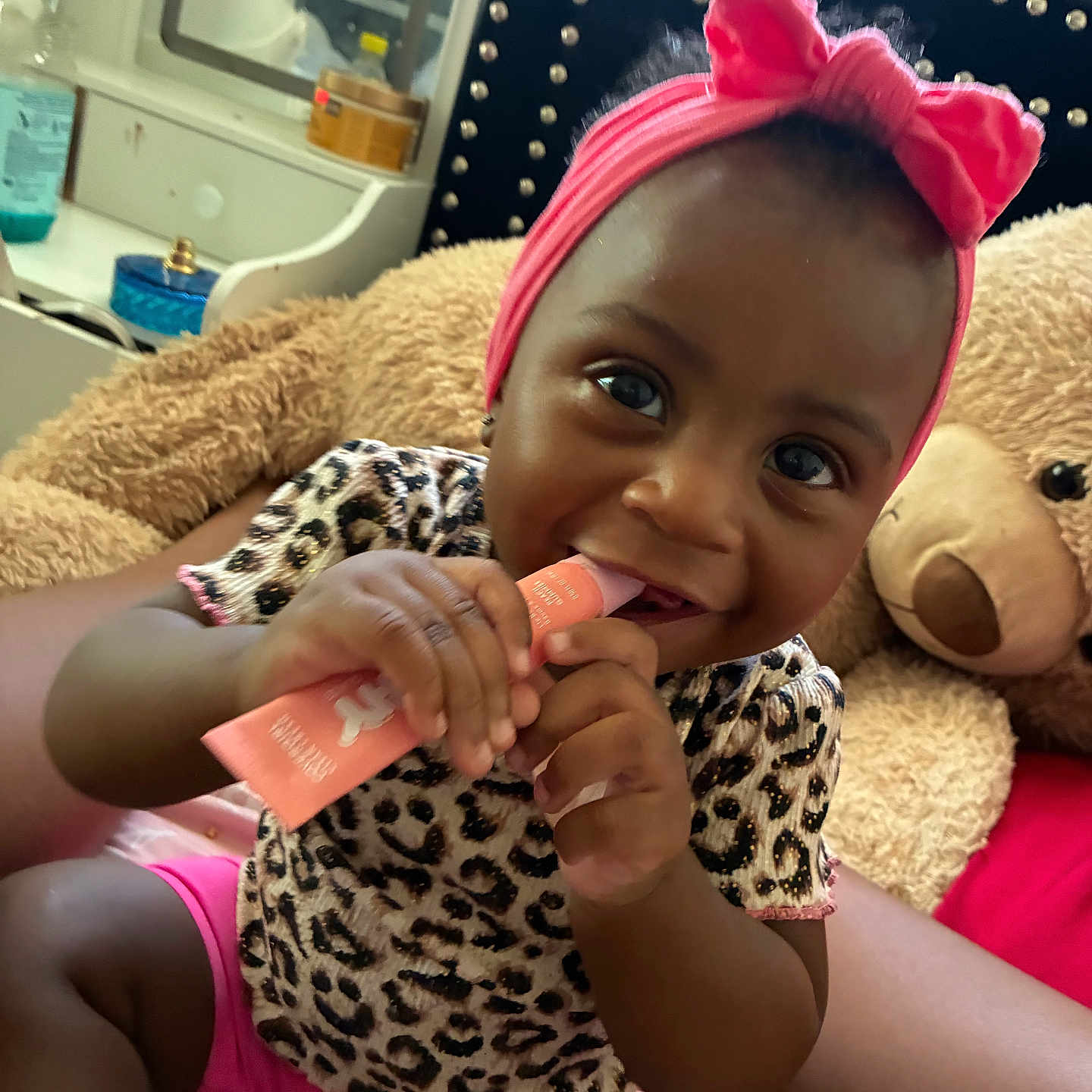 Kehanli joined the competition — help win amazing prizes! baby, child, girl, headband, bow, leopard_print, pink_clothing, teddy_bear, bed, cuddly_toy, smiling, chewing, indoor, cozy, furniture, mirror, bottle, person, happy, cute