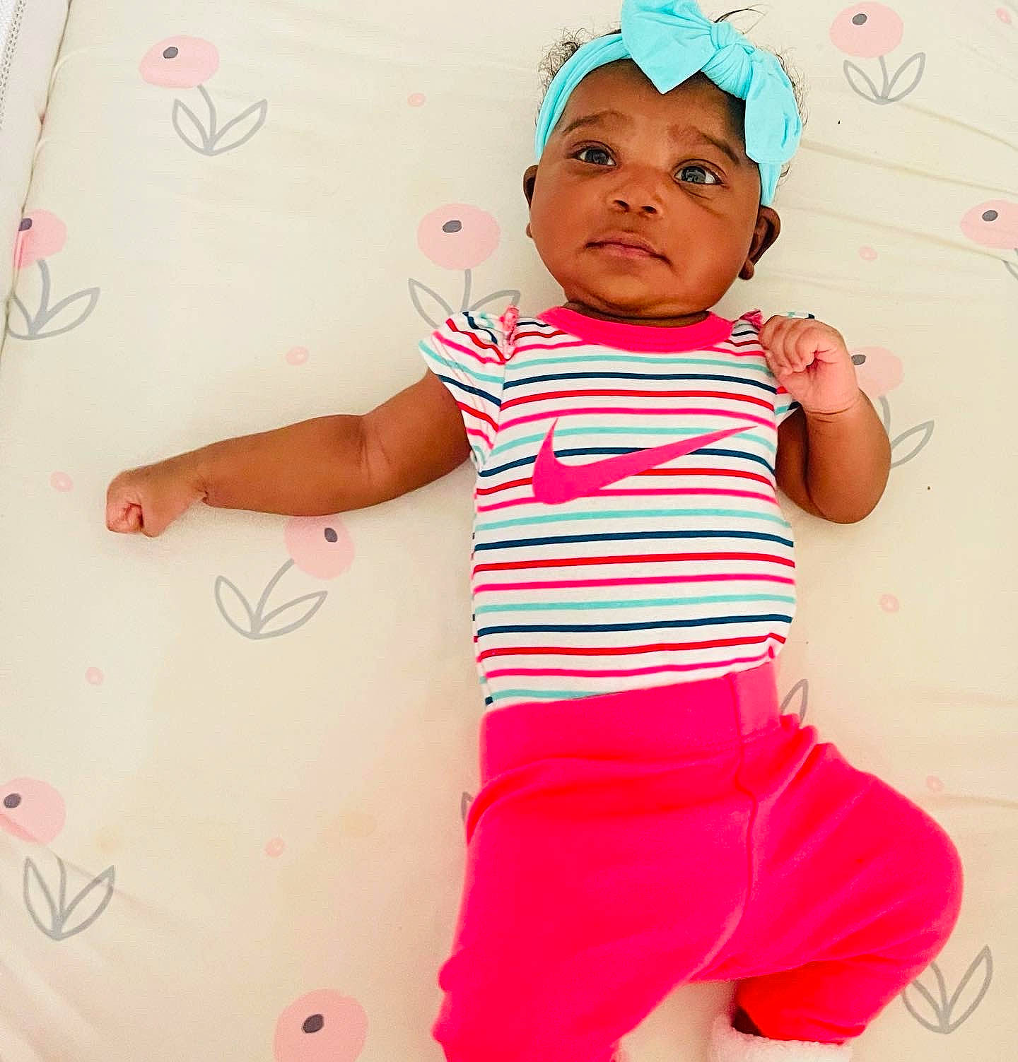 Alani is registered to the contest to win money with this photo: arm, baby, baby_toddler_clothing, child, face, facial_expression, finger, gesture, hand, happy, headwear, human, people, person, photograph, pink, product, sleeve, t_shirt, textile