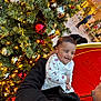 baby, child, christmas_tree, ornaments, red_ball, silver_ball, lights, holiday, smile, happy, person, indoor, festive, clothing, coat, hand, face, celebration, decoration, mall