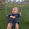Adrastos joined the competition — help win amazing prizes! toddler, child, swing, playground, grass, outdoor, baby_swing, chain, bench, sky, clouds, greenery, person, casual_clothing, happy, park, daytime, young_child, holding, seated