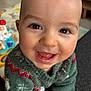 baby, infant, smiling, face, eyes, mouth, teeth, sweater, knitwear, pattern, close_up, portrait, indoor, toy, playmat, crawling, happy, skin, head, cheek