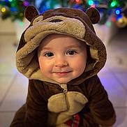 Vittorio a rejoint le concours — aidez-le/la à gagner de superbes lots ! baby, child, bear_costume, hood, plush, smile, portrait, close_up, indoors, holiday_lights, bokeh, cute, eyes, face, tile_floor, christmas_tree, costume, adorable, soft_fabric, sitting