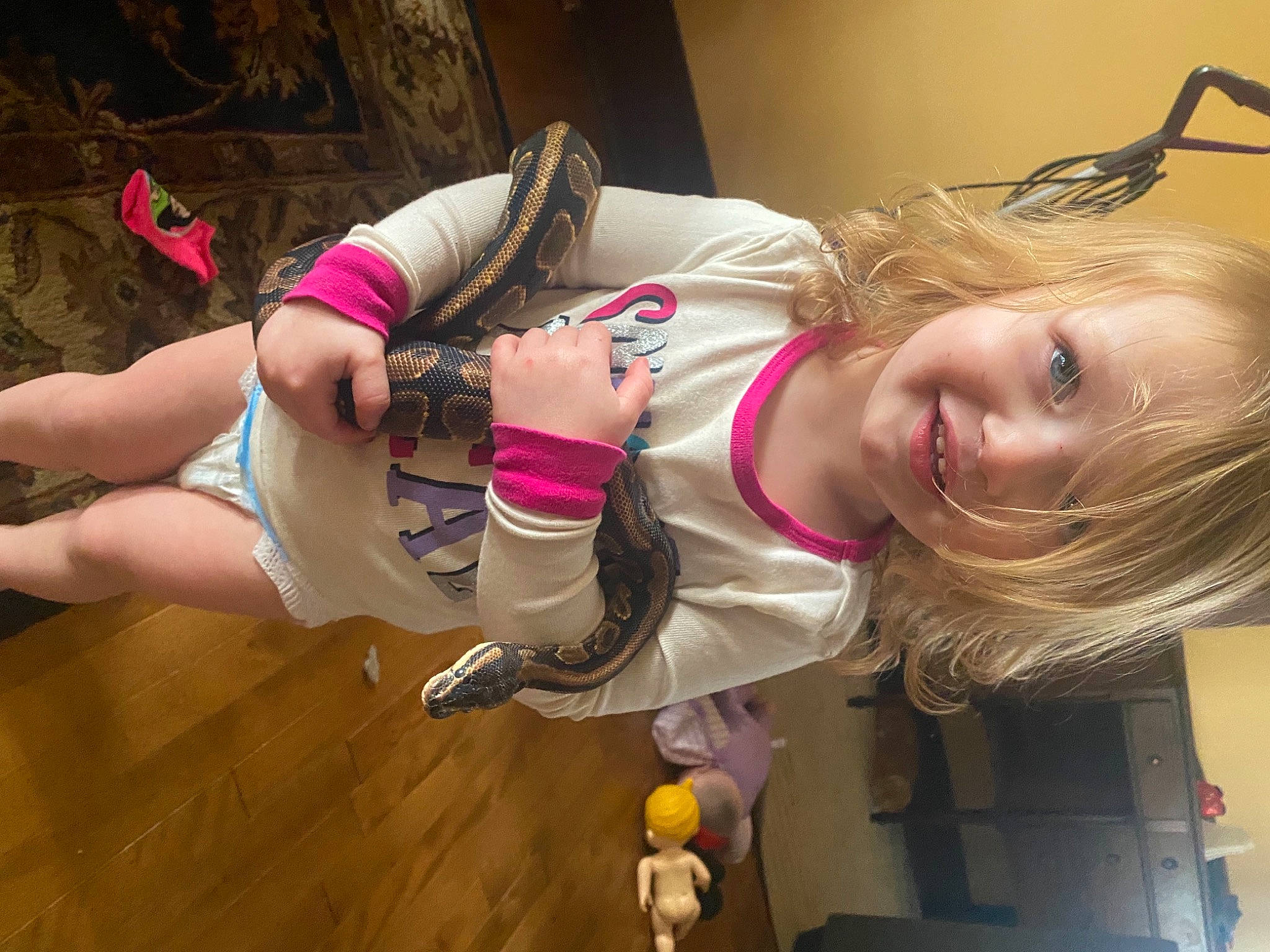 Klover is registered to the contest to win money with this photo: abdomen, blond, chest, eyelash, flooring, fun, hair, happy, human_leg, joy, knee, person, pink, room, smile, thigh, toddler, trunk, wood