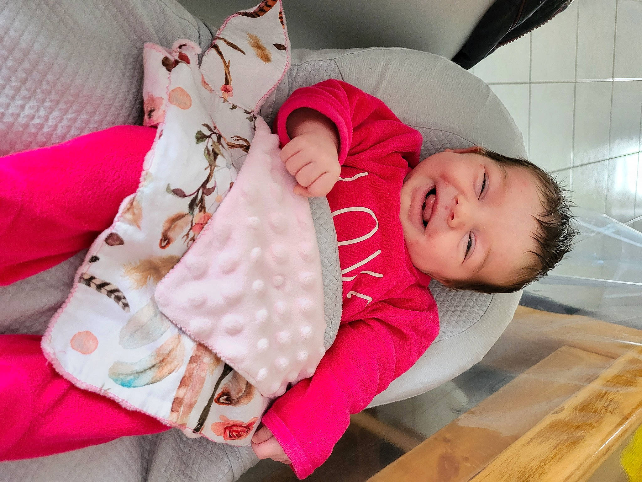 Maeline participe au concours pour gagner de l'argent avec cette photo : baby, baby_products, baby_sleeping, baby_toddler_clothing, carmine, child, comfort, glasses, happy, lap, linens, magenta, pattern, person, product, room, sitting, skin, sleeve, smile
