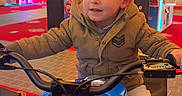 Timeo a rejoint le concours — aidez-le/la à gagner de superbes lots ! amusement, arcade, boy, child, colorful, entertainment, floor, fun, game_machine, hands_on_handlebars, indoor, jacket, lighting, motorcycle_ride, neon_lights, pants, playful, smiling, sneakers, young