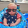Kingston is registered to the contest to win money with this photo: baby, sunglasses, stars, blue, red, white, infant, child, seat, toy, patriotic, clothing, indoor, person, face, hand, cute, expression, fashion, young