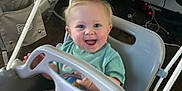 Kingston is registered to the contest to win money with this photo: baby, baby_gear, blonde_hair, casual_clothing, child, computer, floor, furniture, happy, home, indoor, monitor, person, plastic, ropes, seat, smiling, swing, technology, toy