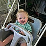 baby, baby_gear, blonde_hair, casual_clothing, child, computer, floor, furniture, happy, home, indoor, monitor, person, plastic, ropes, seat, smiling, swing, technology, toy
