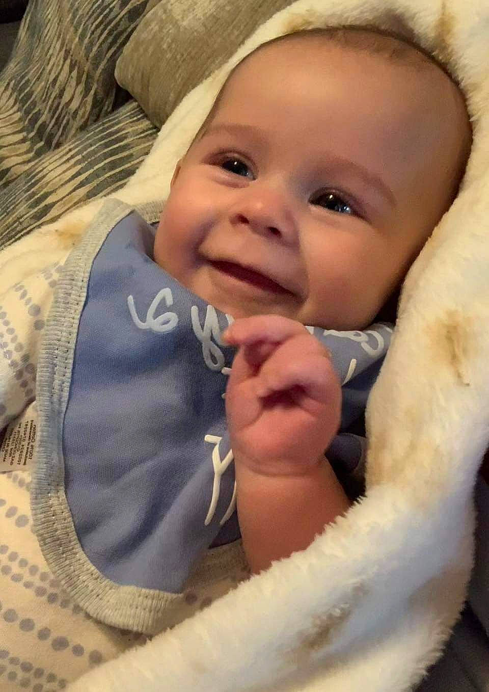Easton is registered to the contest to win money with this photo: baby, baby_products, baby_toddler_clothing, cheek, child, close_up, comfort, eyebrow, facial_expression, finger, gesture, happy, iris, joy, linens, lip, nose, person, skin, smile