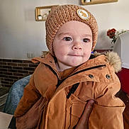 Charly a rejoint le concours — aidez-le/la à gagner de superbes lots ! baby, brown_jacket, child, coat, cozy, curious, cute, decor, expression, face, furniture, hands, hat, indoor, knitted_hat, person, portrait, tattoo, toddler, warm_clothing