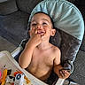 toddler, child, high_chair, messy, chocolate, food, snack, toy, indoor, couch, happy, smiling, face, hand, shirtless, playful, table, seat, person, home