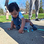 Ray is registered to the contest to win money with this photo: toddler, child, sidewalk, chalk, outdoor, grass, blue_sky, person, playing, casual_clothing, socks, container, summer, daylight, trees, young_child, people, fun, leisure, park