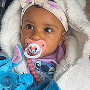 Lyïana participe au concours pour gagner de l'argent avec cette photo : baby, blue, child, closeup, clothing, cute, expression, fluffy_jacket, headband, indoors, infant, mickey_mouse, pacifier, pink, plush_toy, portrait, purple, soft_texture, toy, white