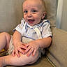 Saban is registered to the contest to win money with this photo: baby, child, smiling, happy, sitting, armchair, clothing, light_blue, skin, hands, legs, indoors, portrait, cute, infant, person, face, eyes, mouth, furniture