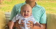 Saban joined the competition — help win amazing prizes! baby, child, man, smiling, outdoor, bench, cap, greenery, happy, person, holding, cushion, shirt, pants, portrait, daylight, family, grass, nature, sitting