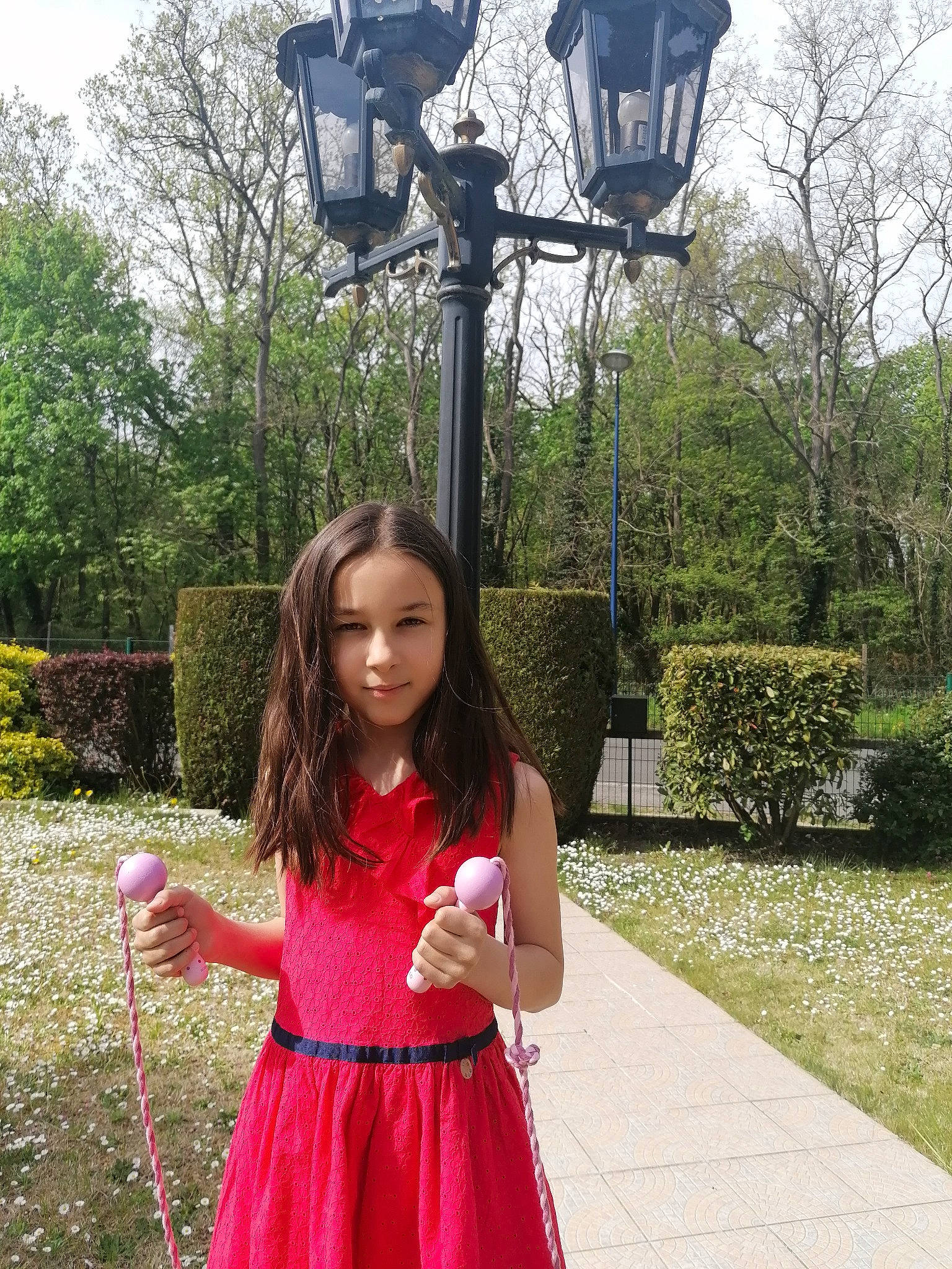 Eve participe au concours pour gagner de l'argent avec cette photo : botany, clothing, grass, green, happy, human_body, joy, leaf, leisure, nature, person, photograph, pink, plant, public_space, sky, sleeve, standing, street_light, tree