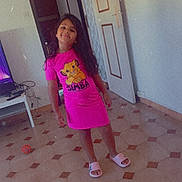 Neyla participe au concours pour gagner de l'argent avec cette photo : cables, casual, child, door_frame, floor_tiles, girl, home, indoor, long_hair, open_door, pink_dress, room, simba_character, slippers, smile, standing, television, tiled_floor, toy_ball, wall